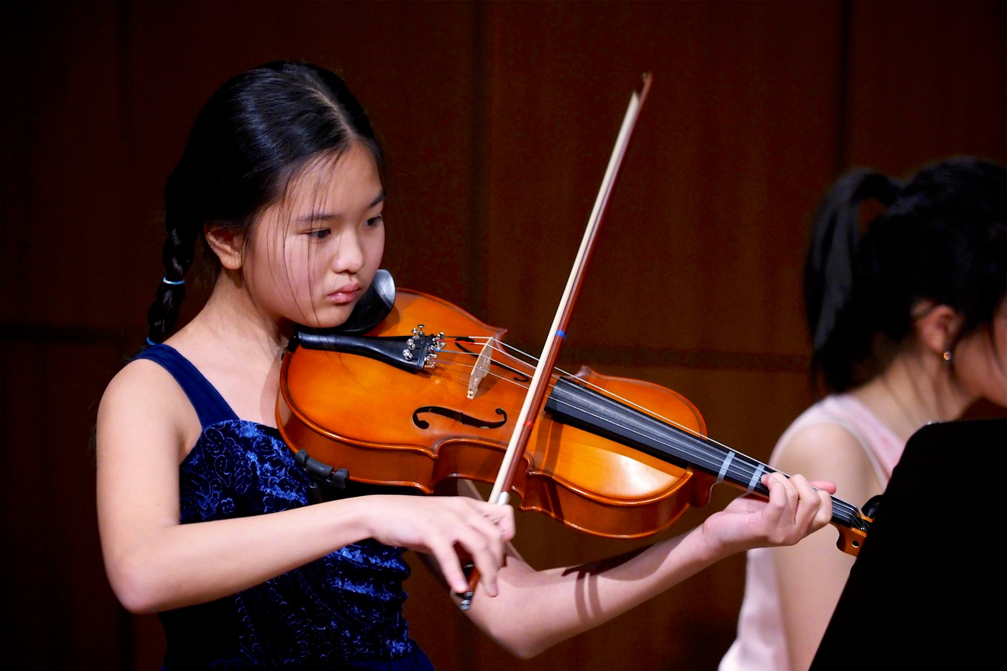 Student playing violin in blue dress