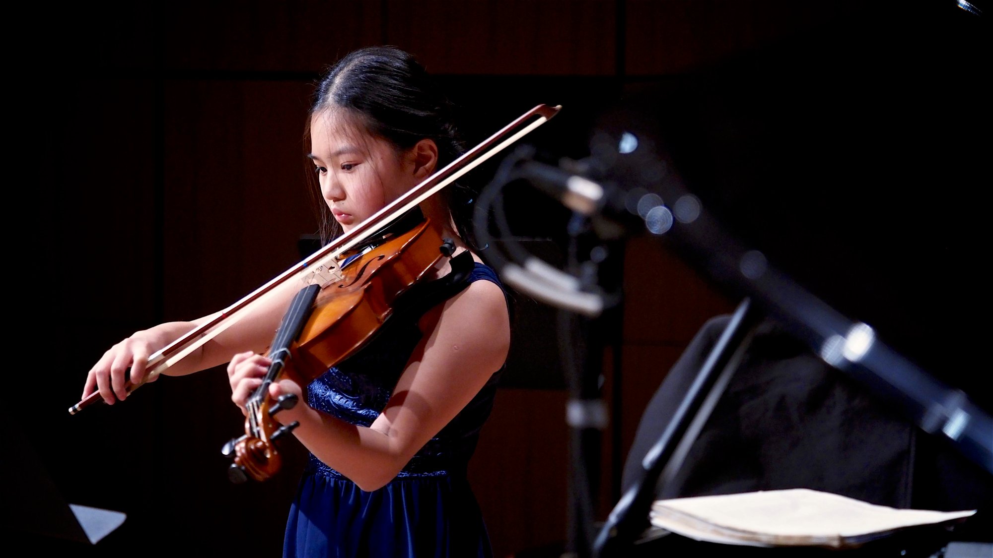 Student performing violin solo on stage