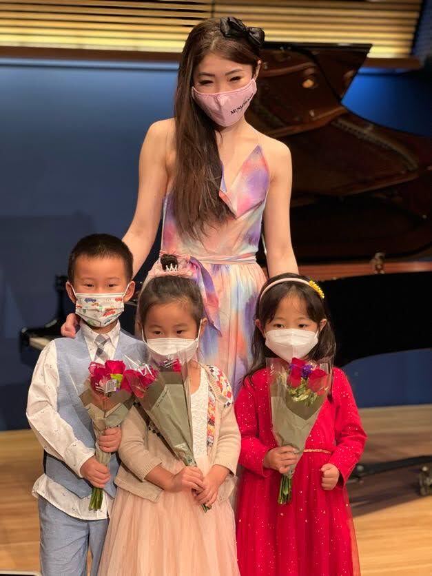Cristina with three young students holding flowers at recital 2022