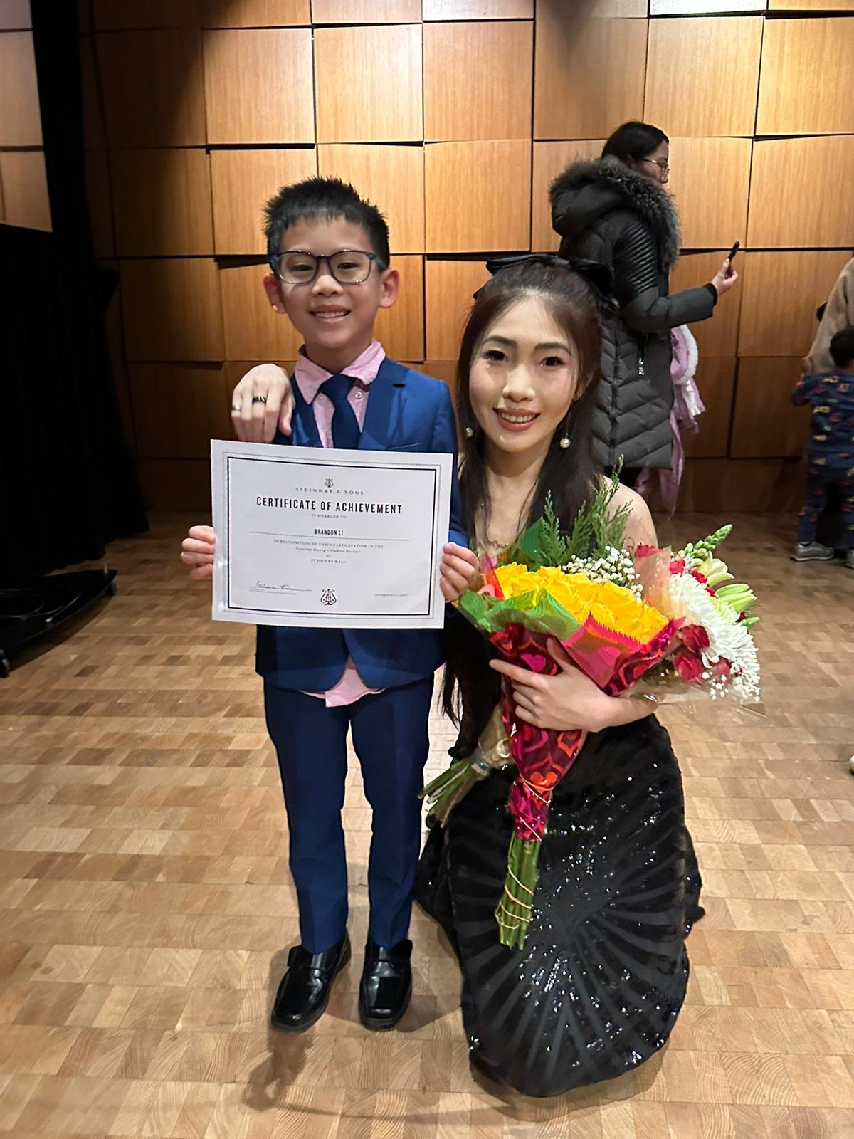 Cristina with two students Jaydon and Tyler holding Steinway certificates at recital 2023